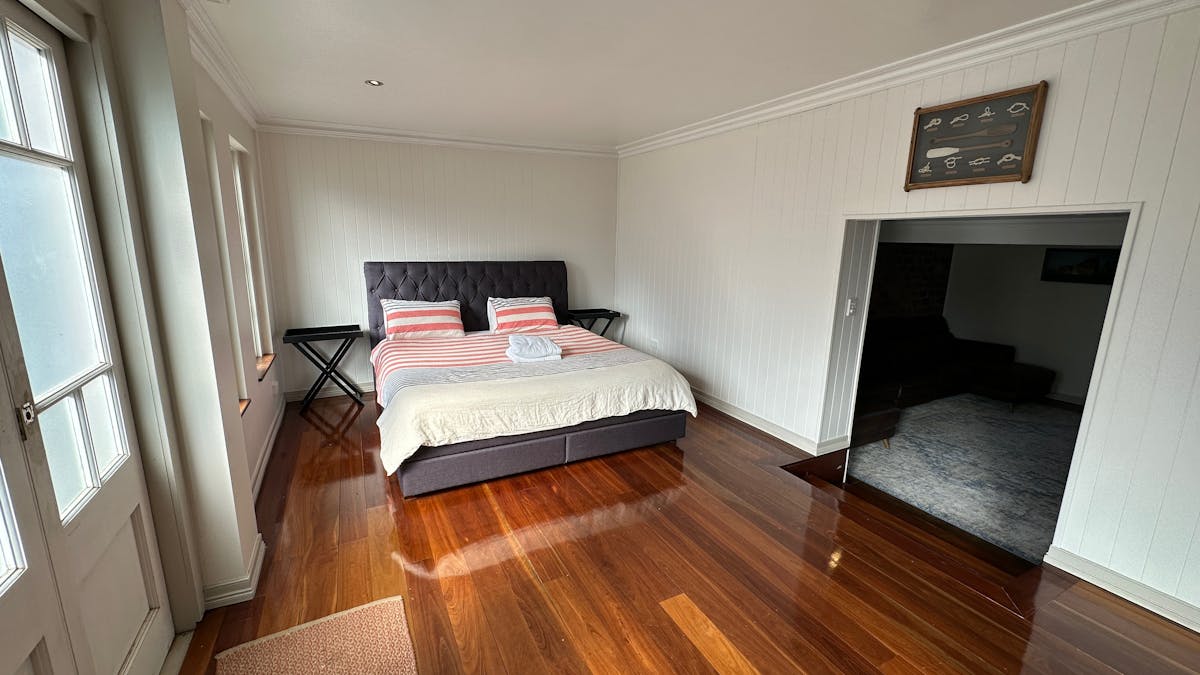 King sized bedroom with reading chair and access to back garden