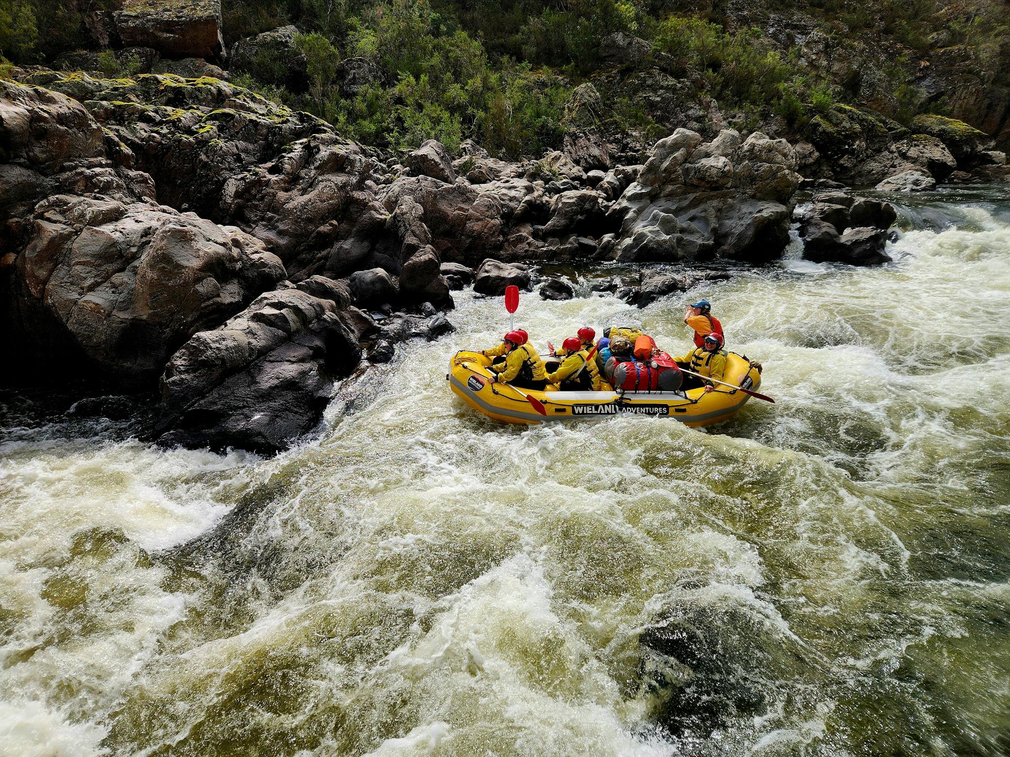 Female raft guide about to go over the main drop in Georges's Mistake II rapid with clients.