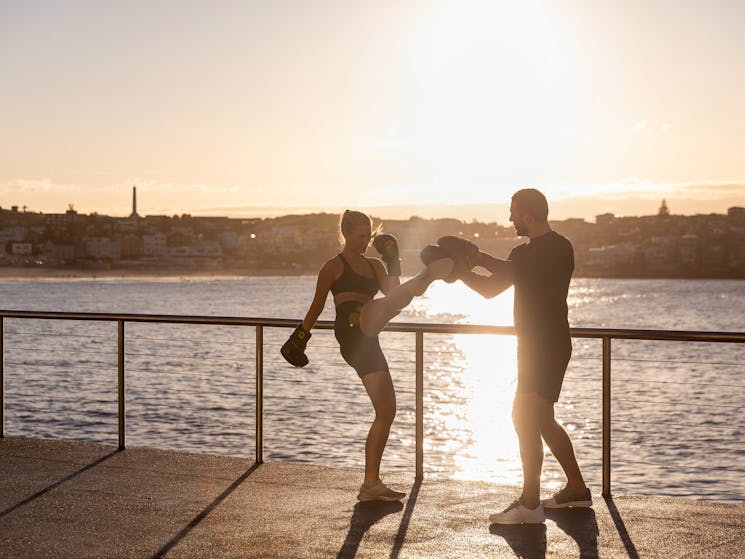Woman working out with a personal trainer at Bondi Beach, Sydney