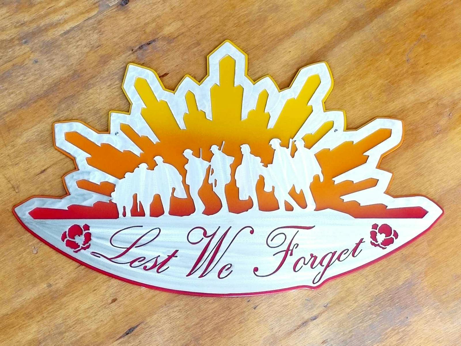 An artwork showing soldiers in a rising sun with the words lest we forget with poppies.
