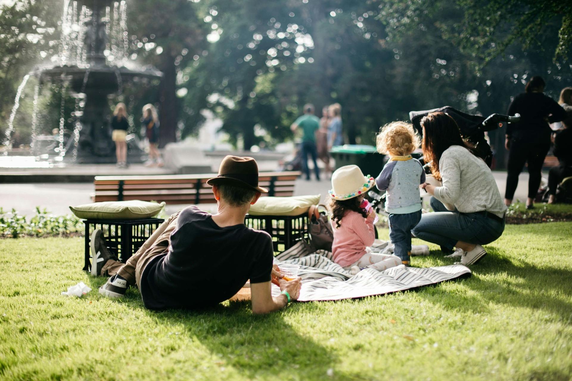 Family relaxing in a park near a fountain