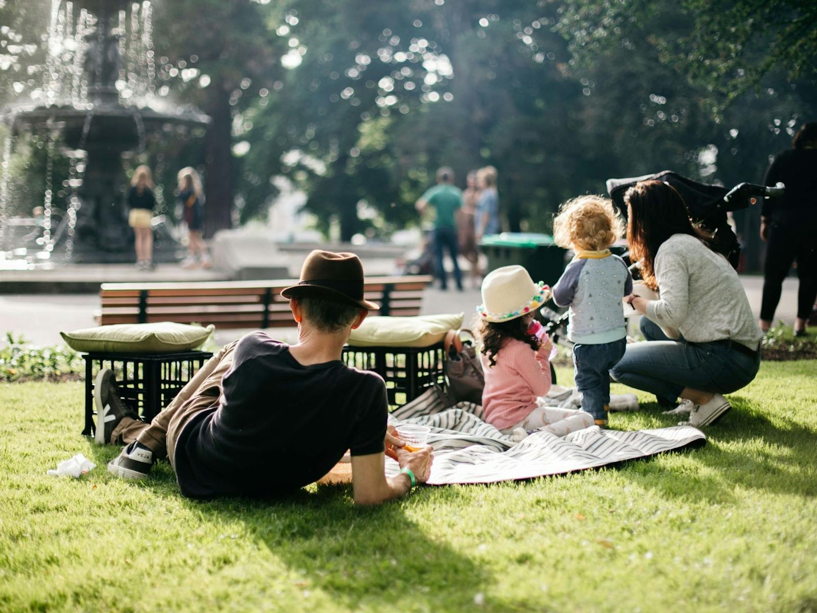 Family relaxing in a park near a fountain