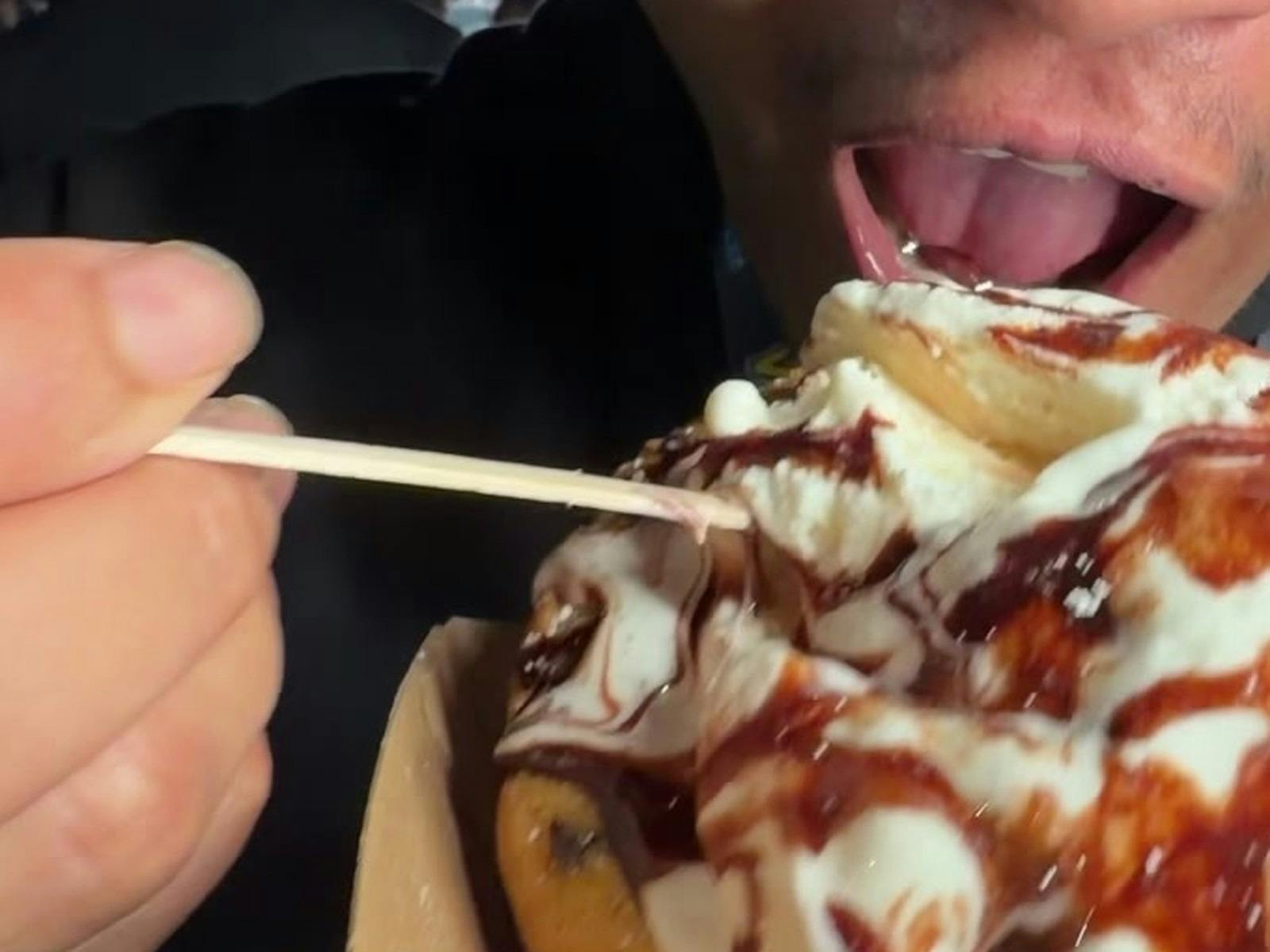 Close-up of cookie dough pie with cream and chocolate sauce being eaten