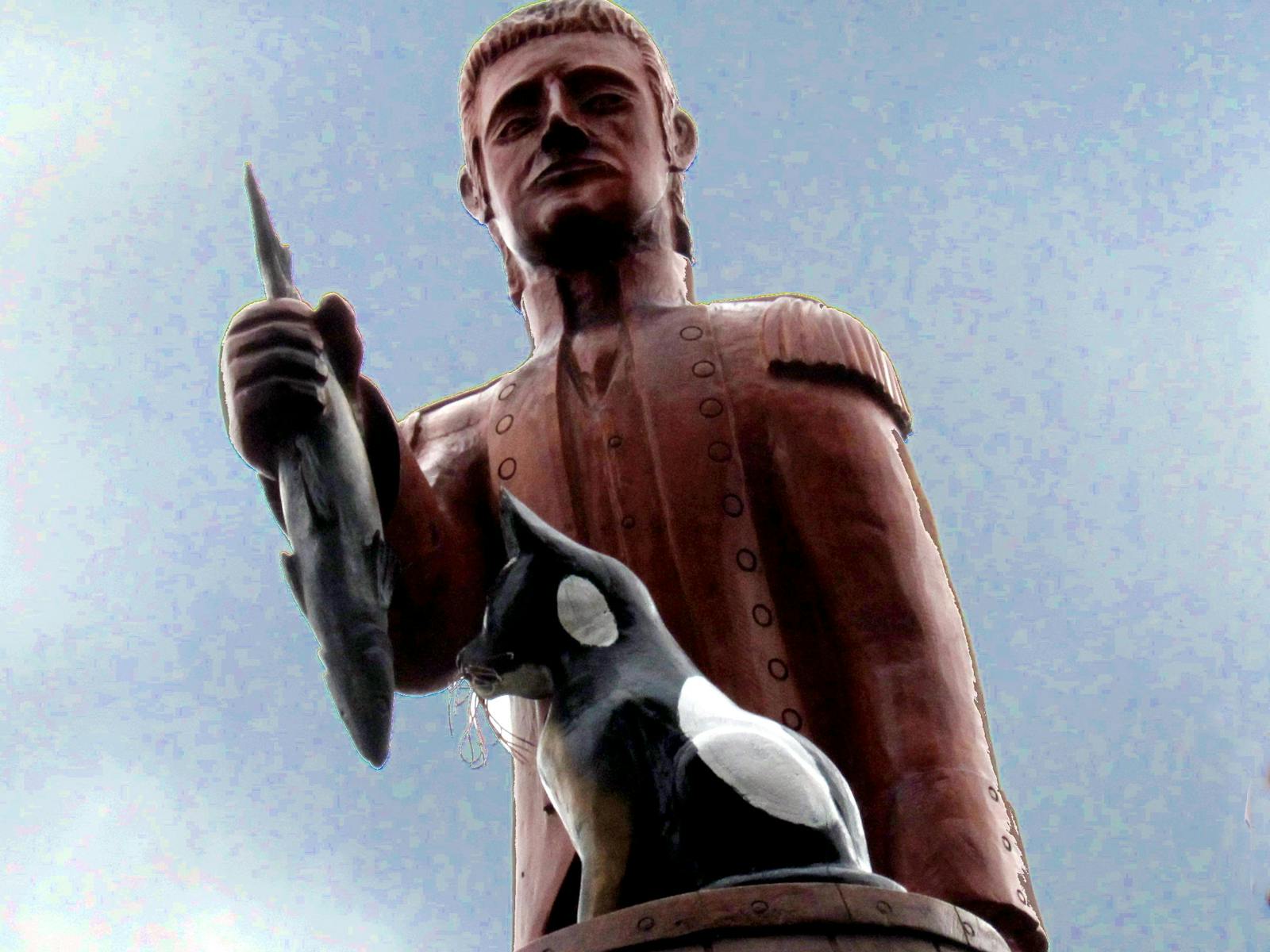 A carved tree statue of Matthew Flinders and Trim the cat.
