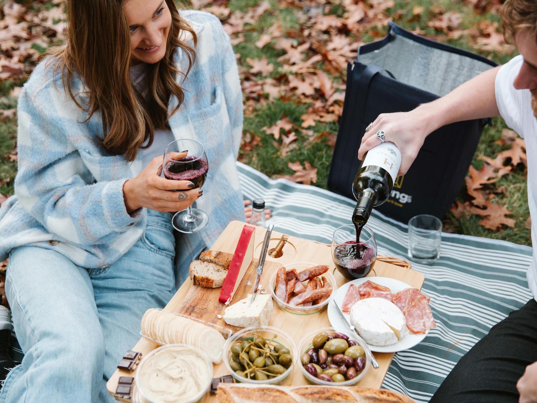 Couple enjoying AmazingCo Mystery Picnic Date with wine