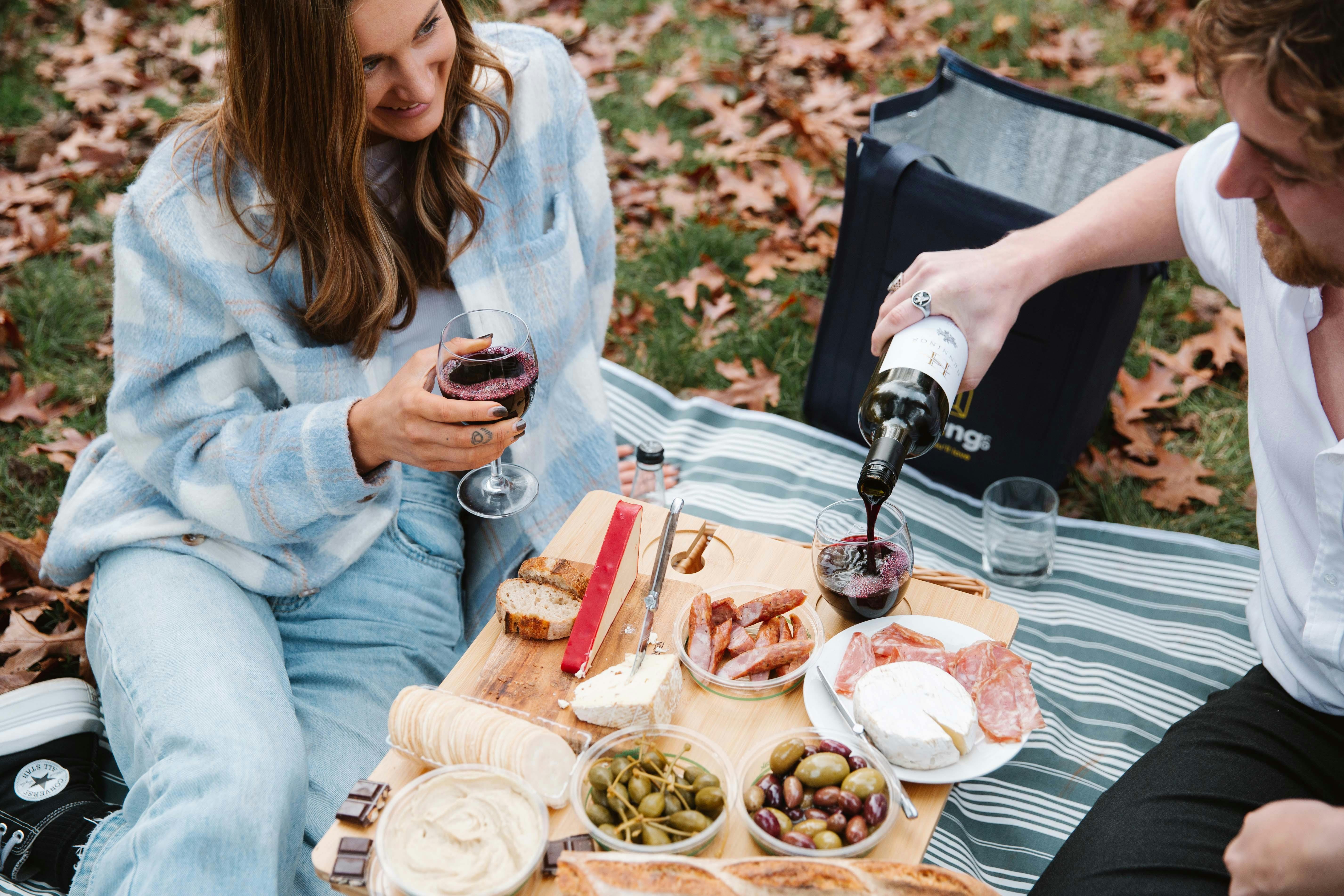 Couple enjoying AmazingCo Mystery Picnic Date with wine