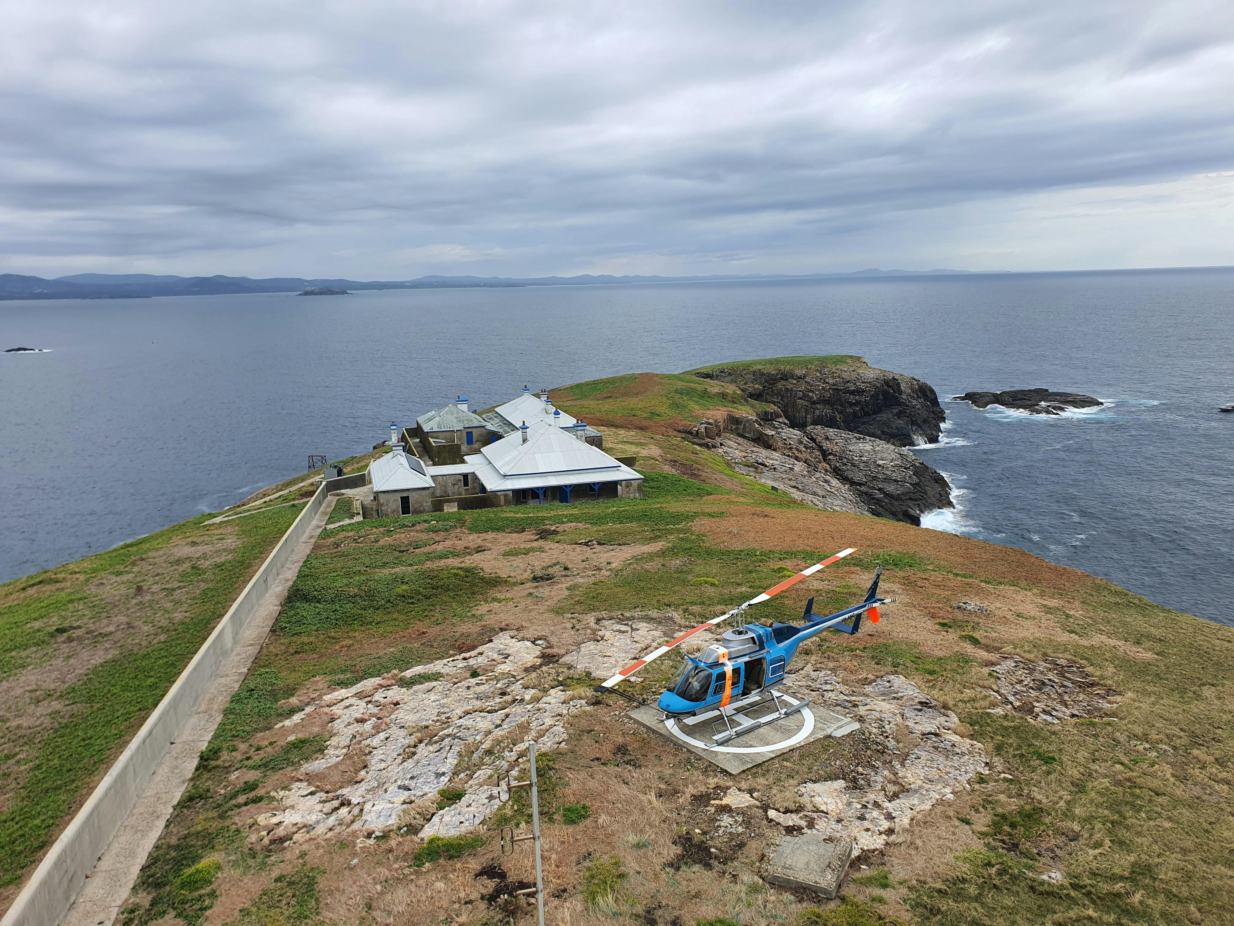 Helicopter landed on a helipad at South Solitary Island. View from up high looking down