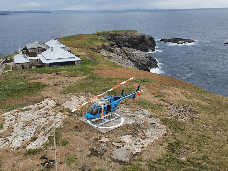 Helicopter landed on a helipad at South Solitary Island. View from up high looking down