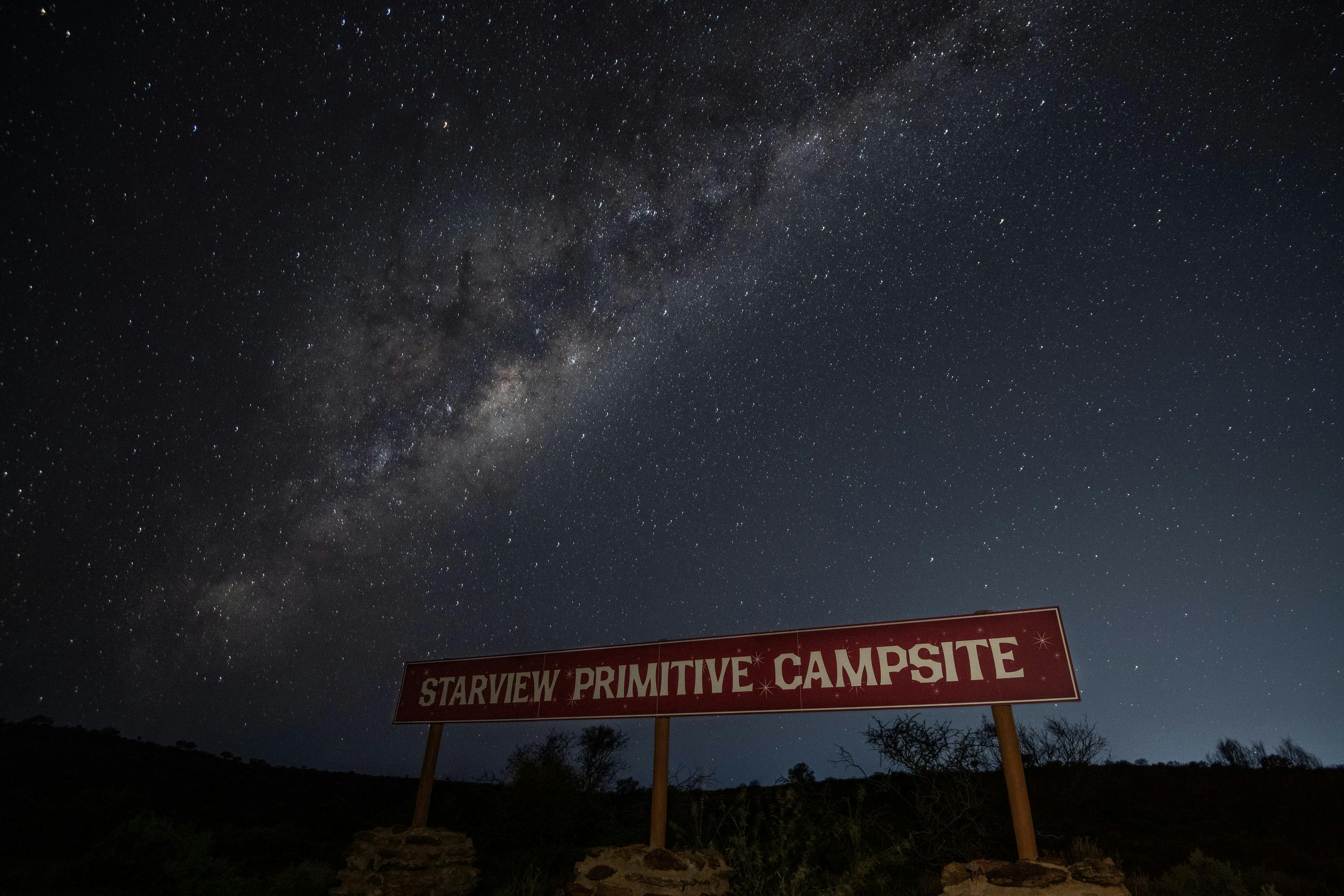 Starview Campsite entry sign at night showing the milky way