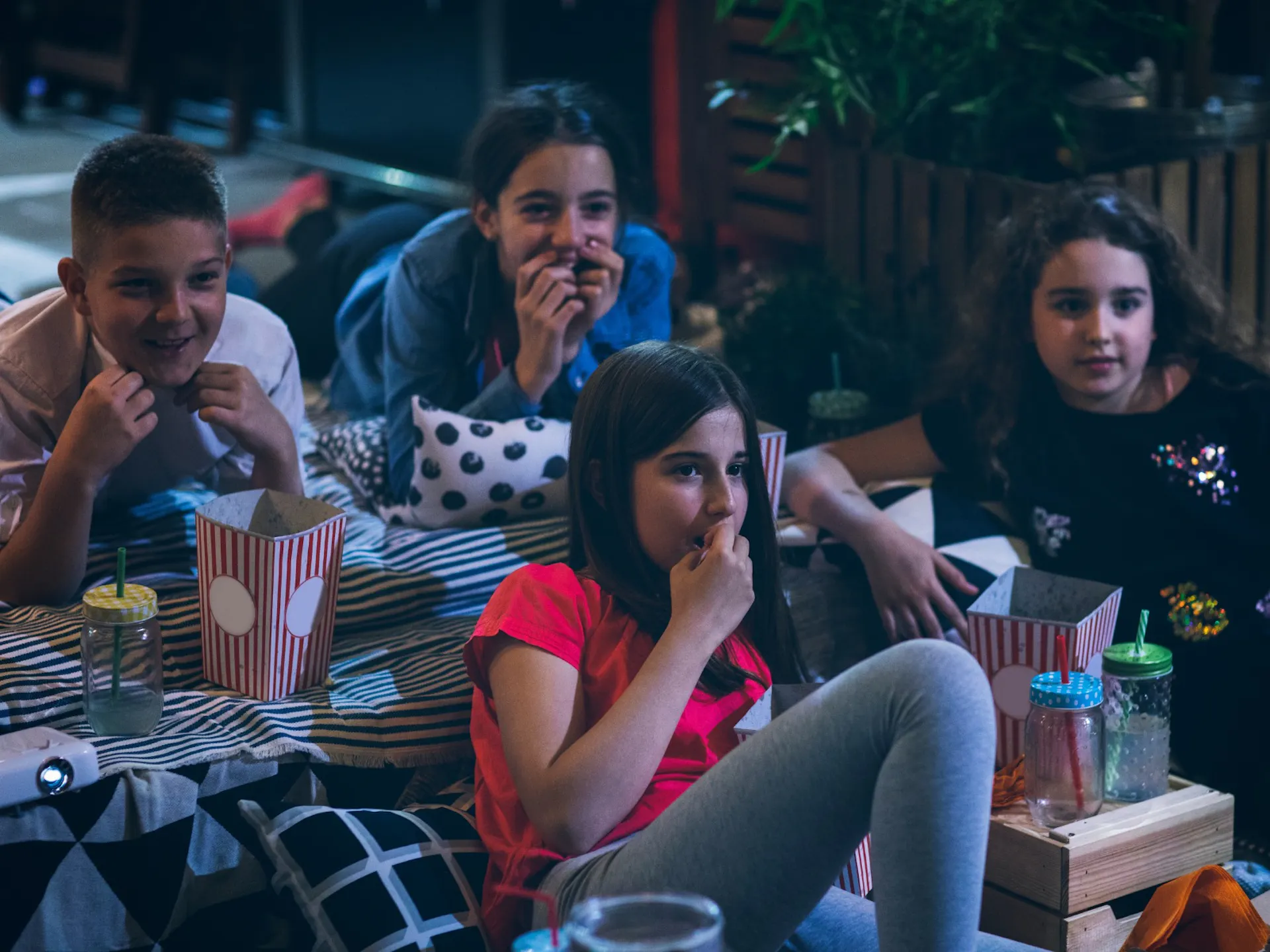 Kids eating popcorn and snacks whilst watching a movie