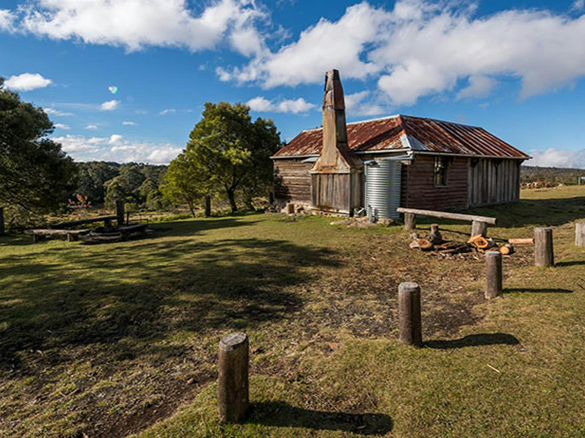Alexanders Hut, with woodpile and barbecue area with benches for day use. Photo: John Spencer/OEH