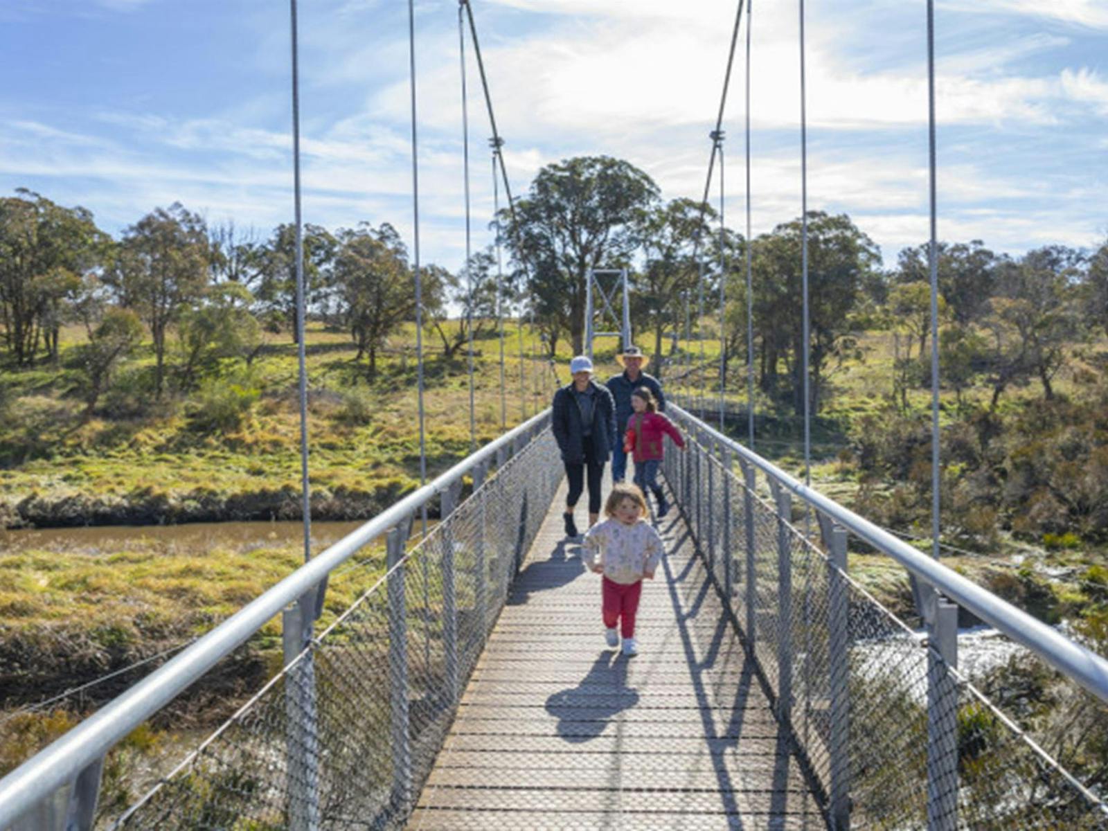 Adults and children walking on suspension bridge Oxley Wild Rivers National Park. Photo: John Smith