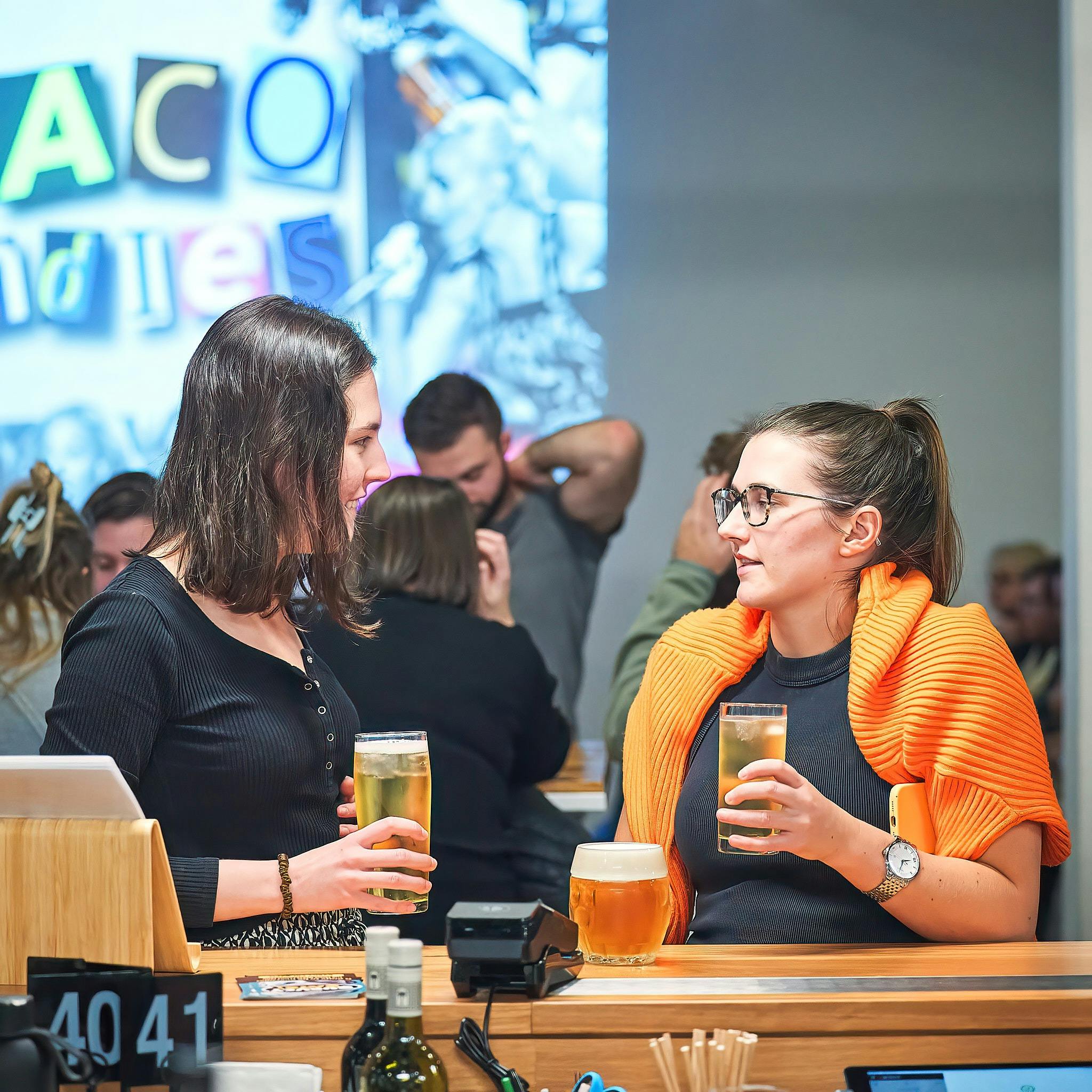 Two people holding drinks at quiz