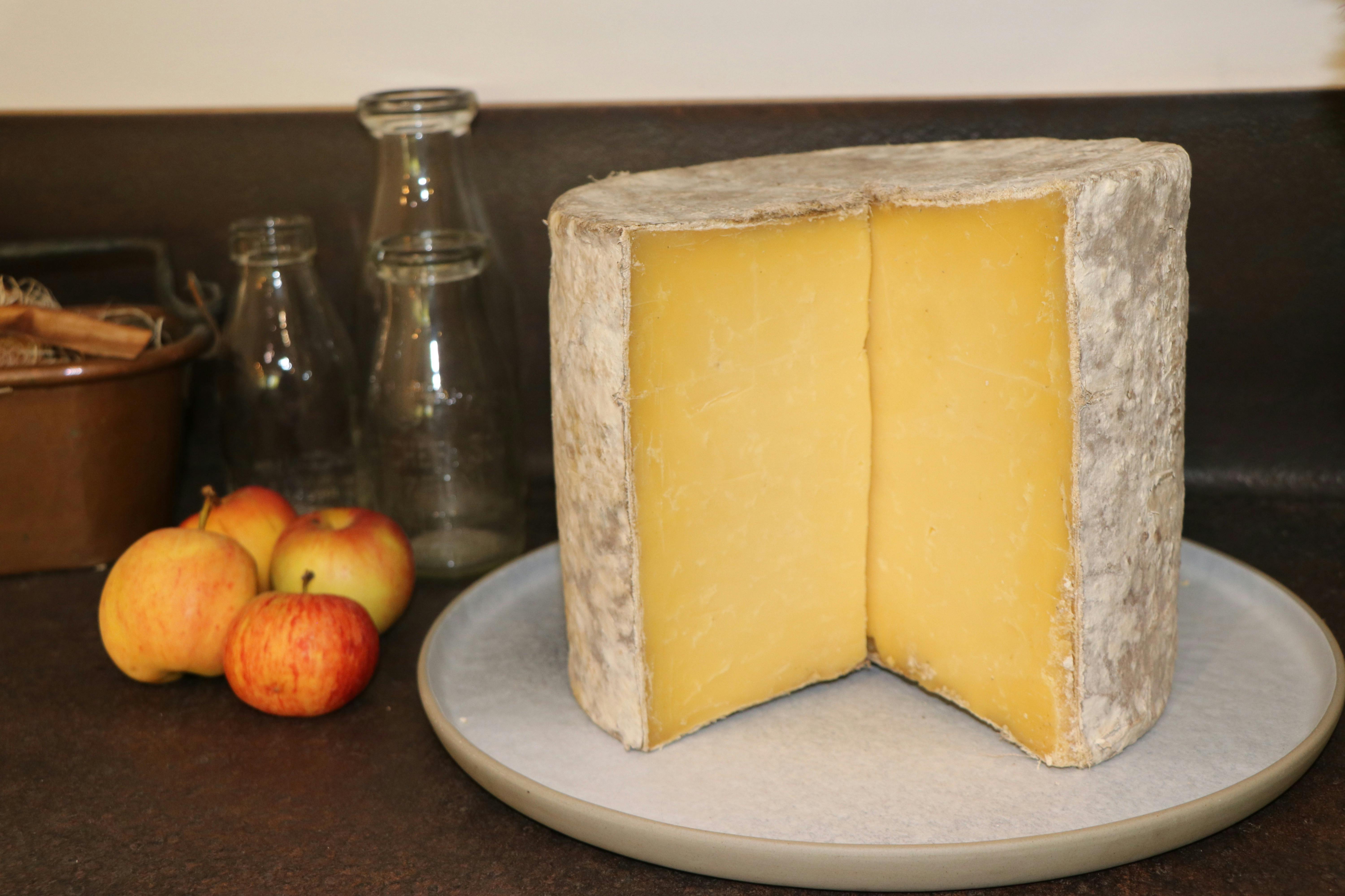 Threequarter wheel of Granite cheese, with apples and milk bottles