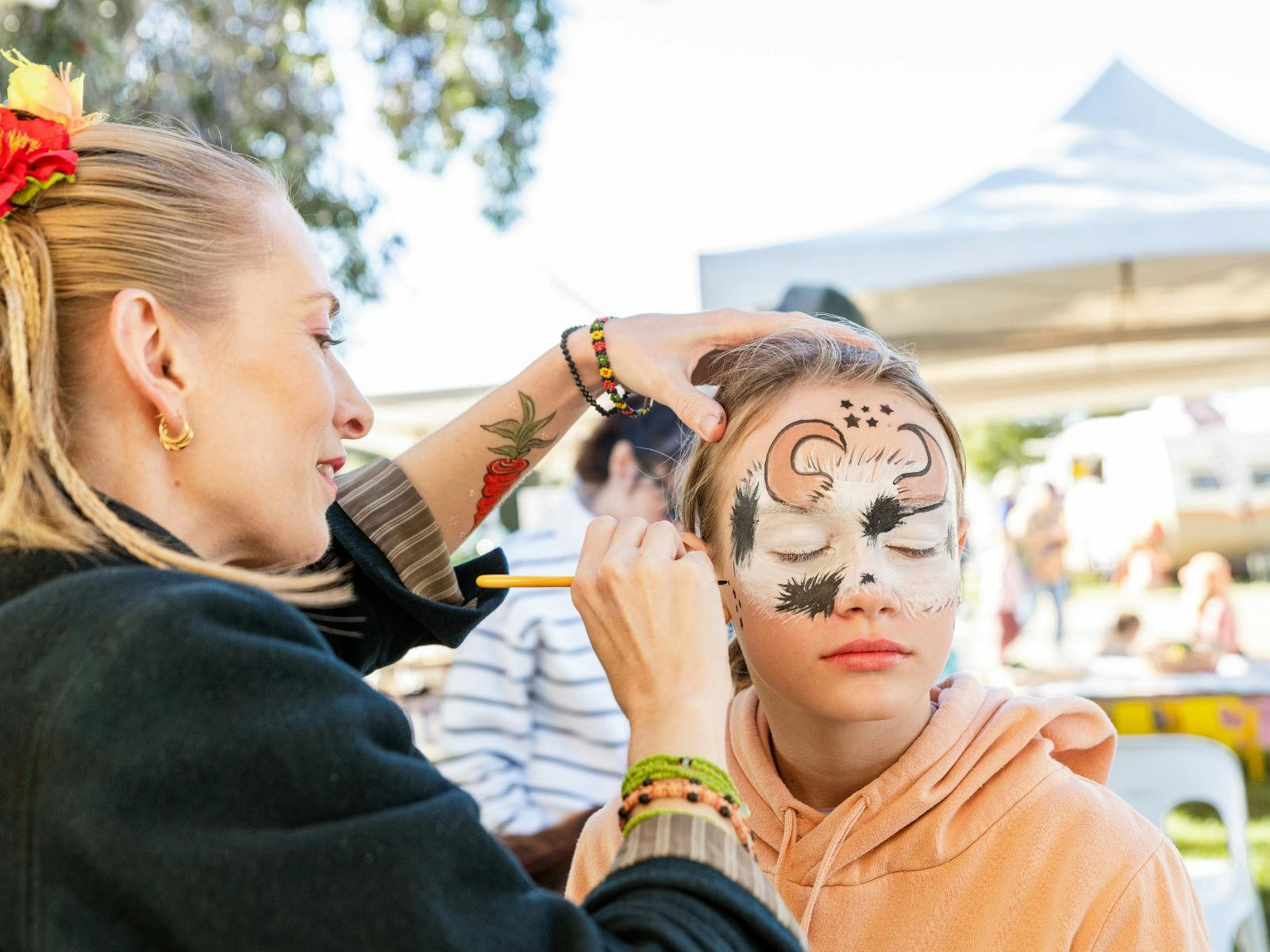 Child getting their face painted at the Winter Harvest Festival