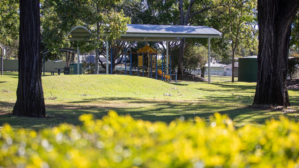 trees and hill, with kids playground, that shelter over it.
