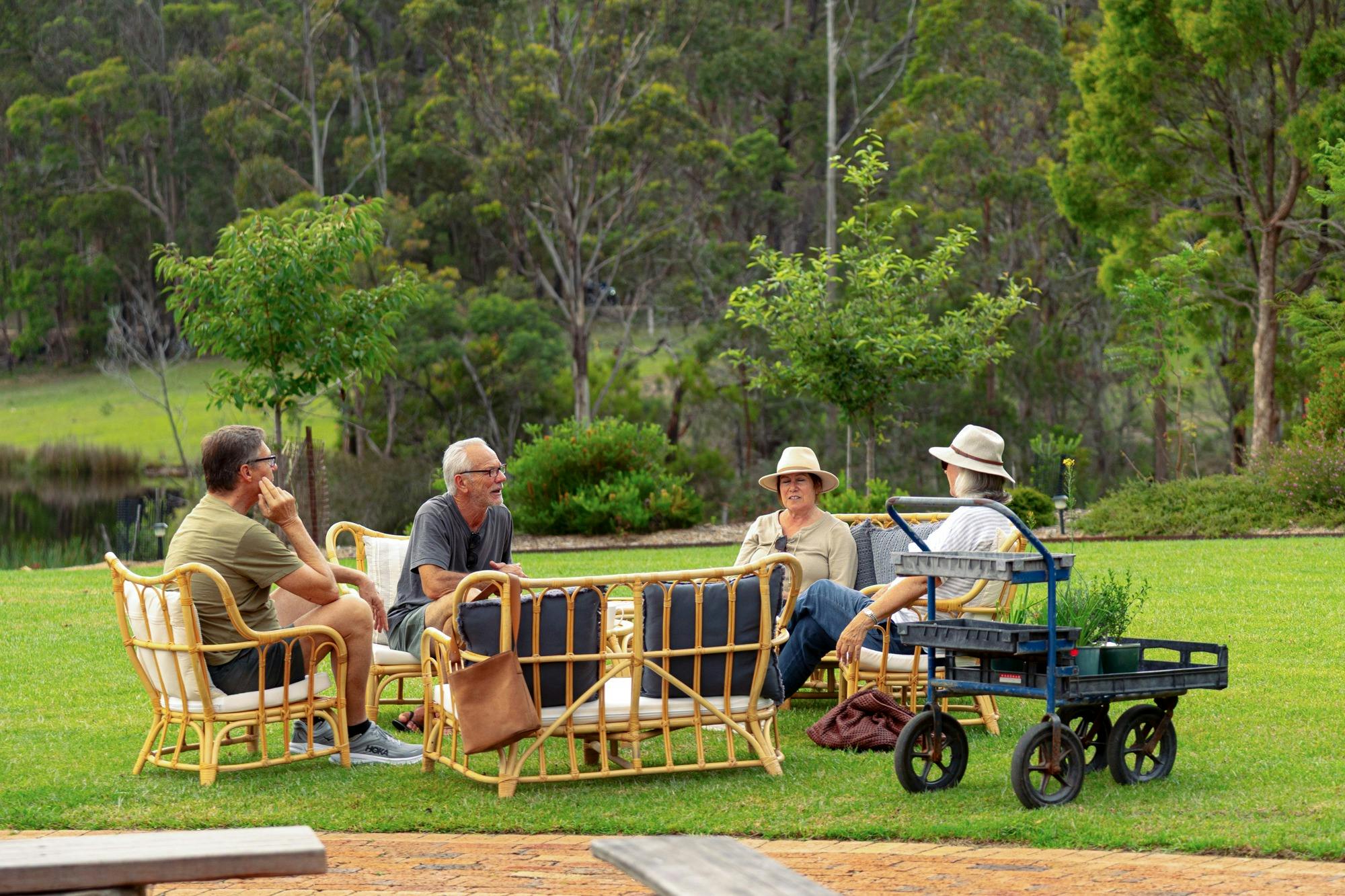 A group of people relaxing with hot drinks and enjoying live music at an outdoor venue.