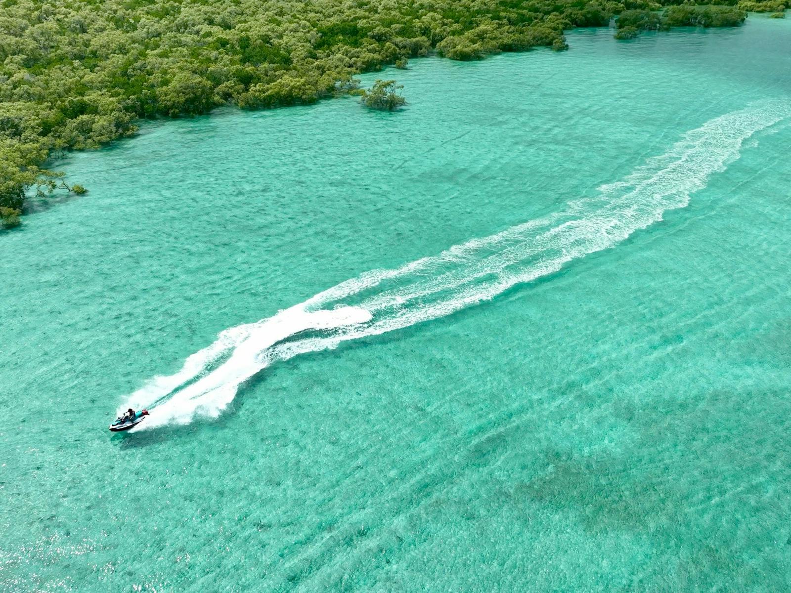 Tour customer driving through crystal blue waters at North Stradbroke Tour customer driving through crystal blue waters at North Stradbroke
