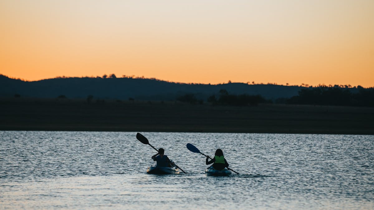 photo of two kayakers on Leslie Dam at sunset