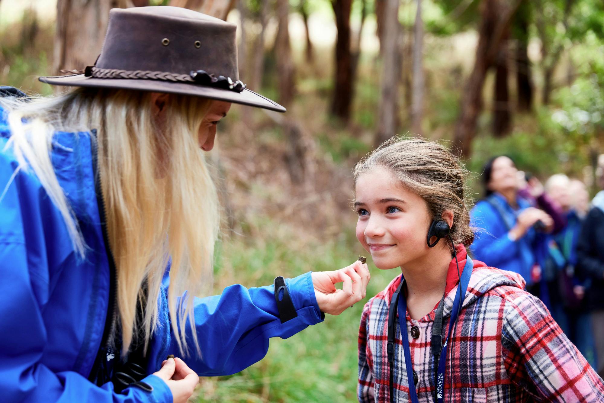 A tour guide showing something to a young tour participant
