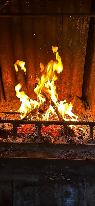 A campfire inside a shelter burning brightly.