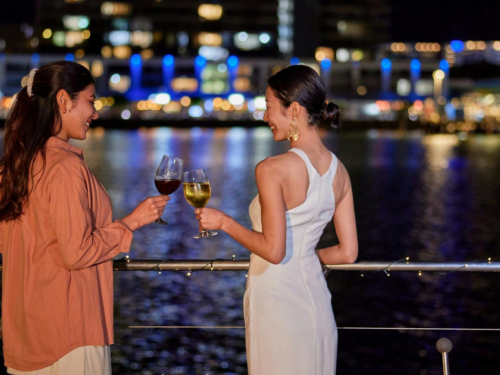Ladies having a drink on the deck of Spirit of Cairns at nighttime