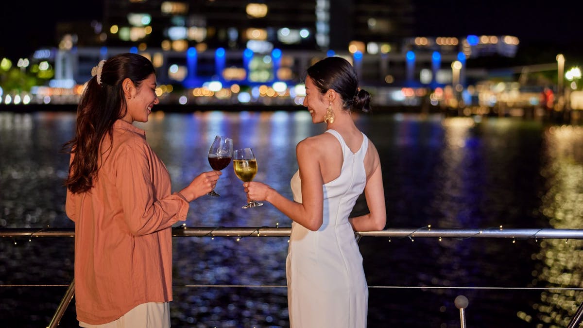 Ladies having a drink on the deck of Spirit of Cairns at nighttime