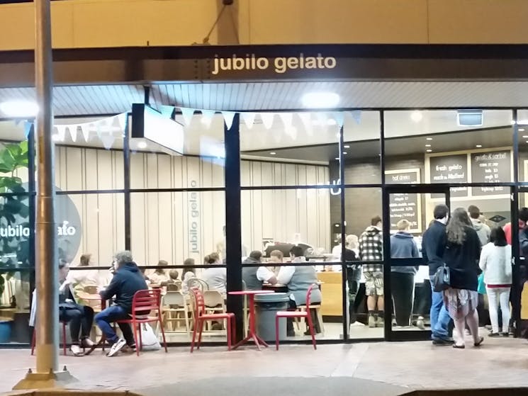 Photo of Jubilo Gelato building exterior showing night time crowds.