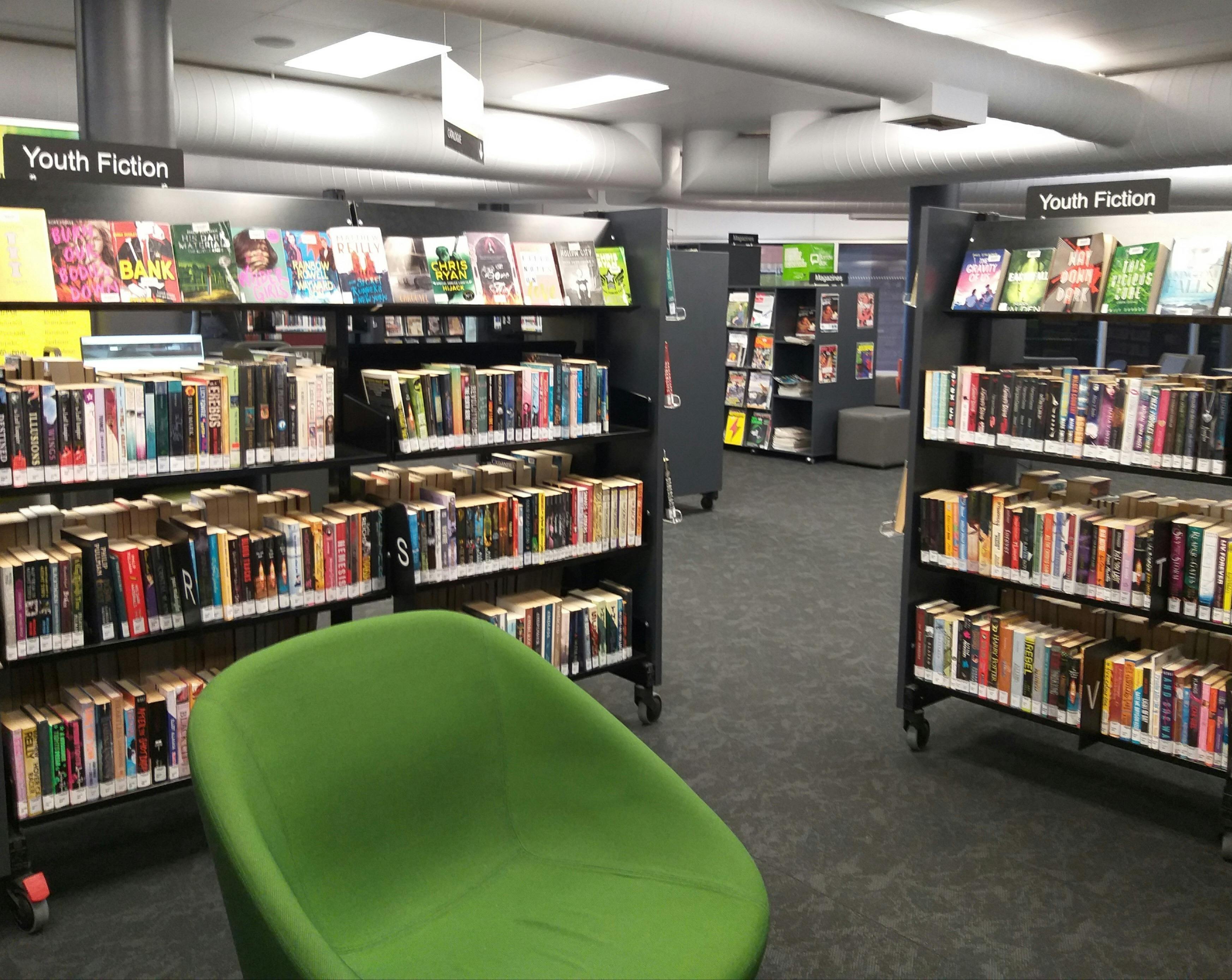 Youth fiction section and green chair
