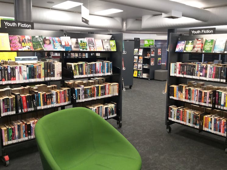 Youth fiction section and green chair