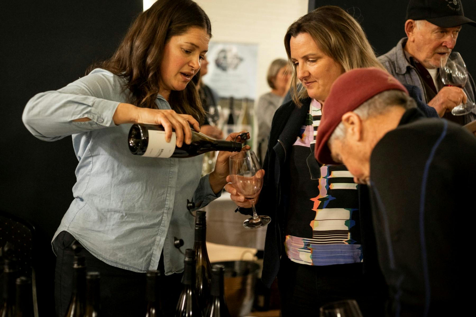 woman pouring wine in a glass for another woman