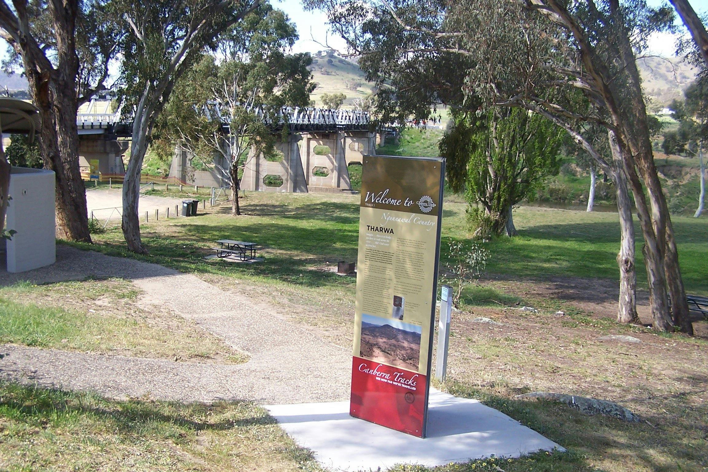 Tall information panel with park and bridge in background