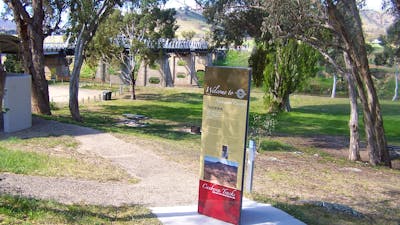 Tall information panel with park and bridge in background