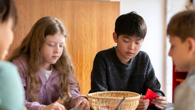Children seated at a table doing craft activities