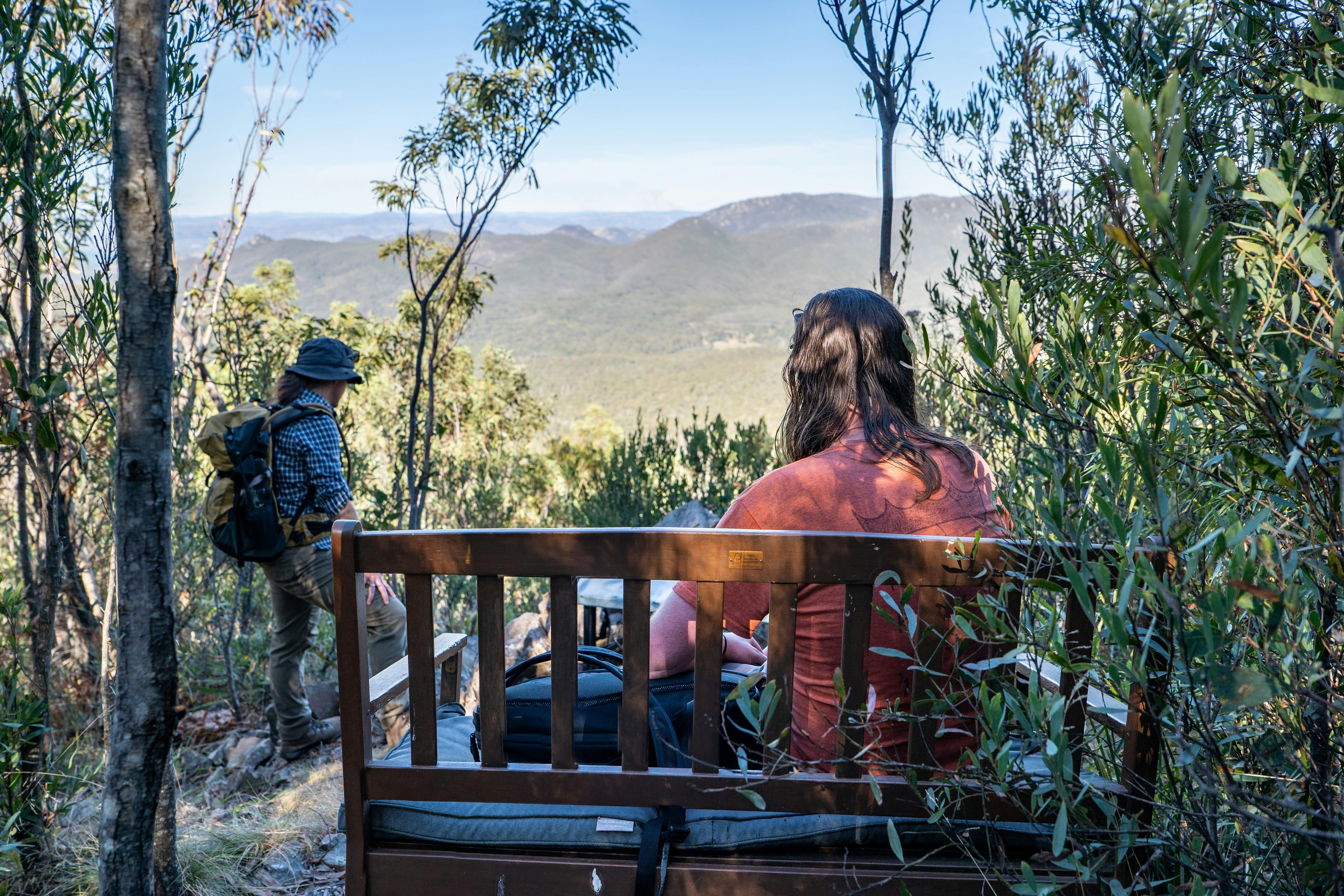 Two people at a bench lookout in the middle of a steep incline on the Snowy Corner Track