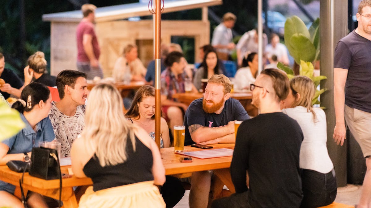 Seated group of people in bustling beer garden.