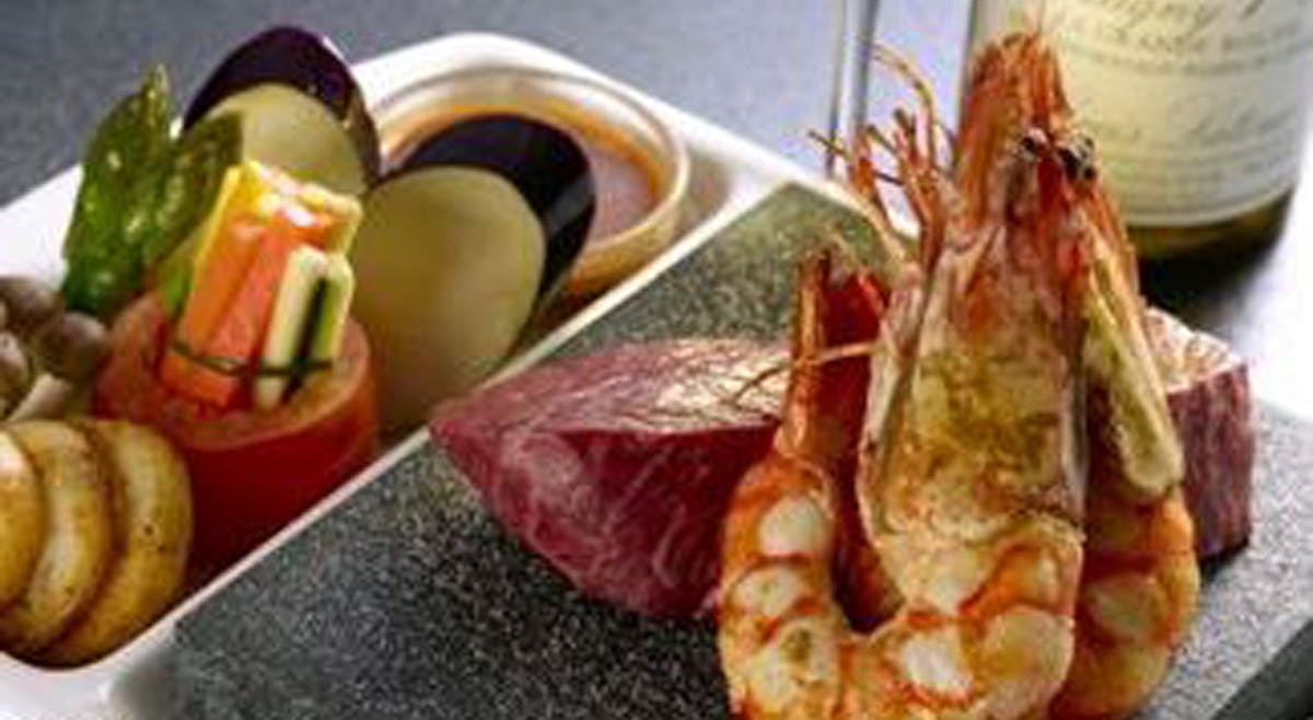 steak and prawns on stone grill