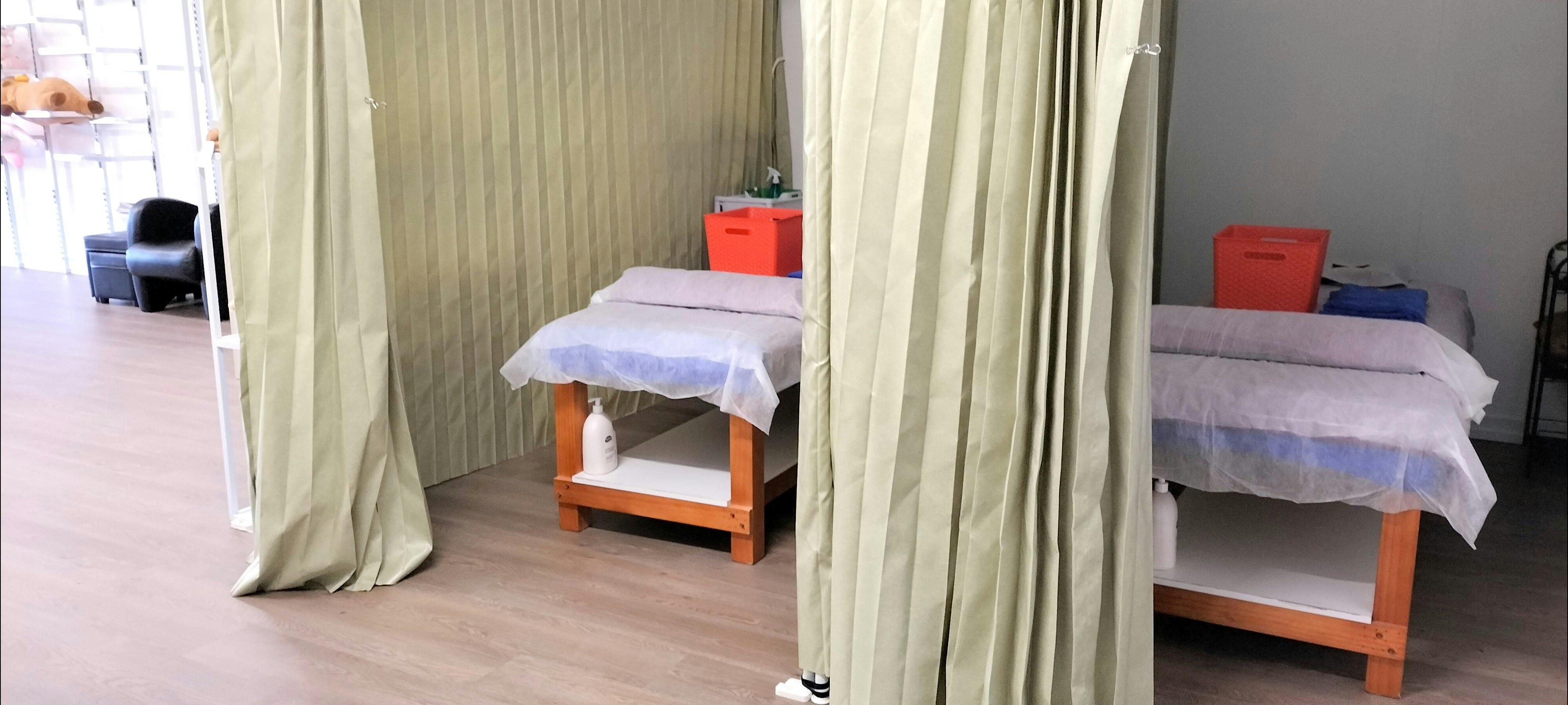 兩張按摩床用簾子隔開，乾淨整潔，隨時可以使用。