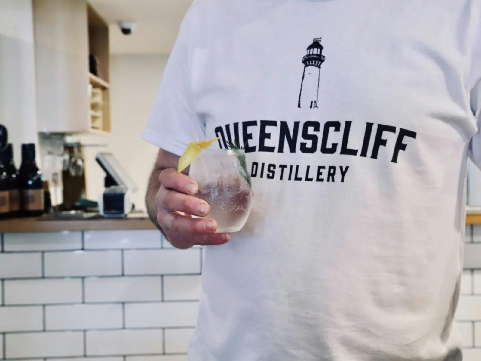 Person wearing Queenscliff Distillery tshirt with a cocktail