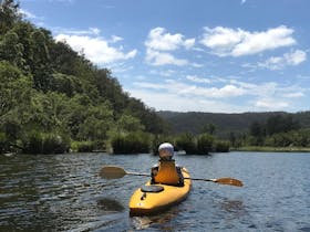 A lone Kayaker is drifting down the Nymboida River Trail looking at the spectacular river scenery.
