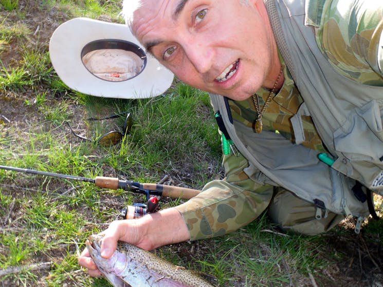 Man leaning down with his trout