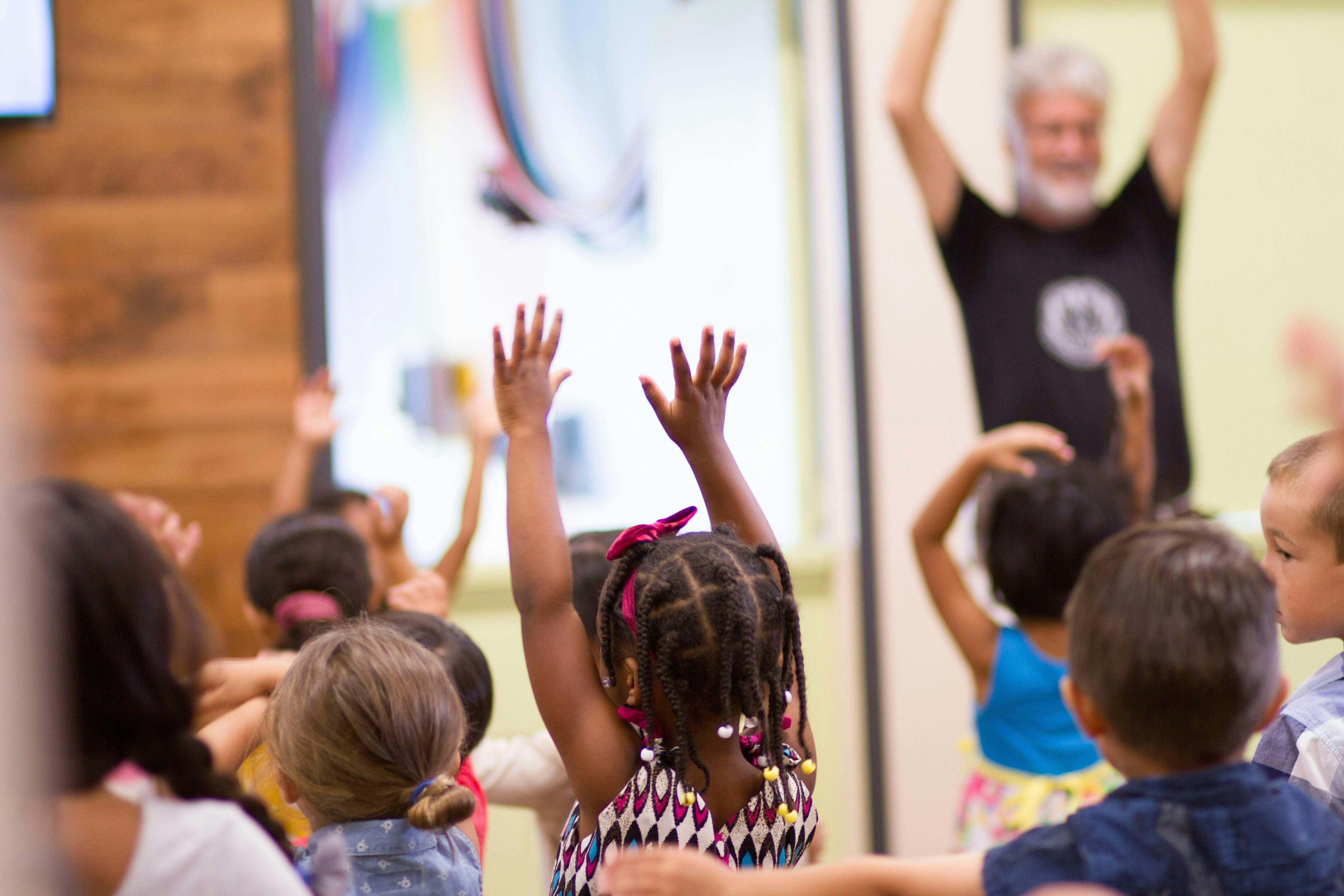 A child raises their arms during a family activity