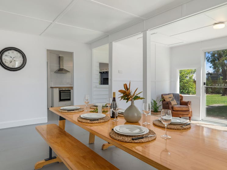 Timber dining table with bench seats and view to kitchen.