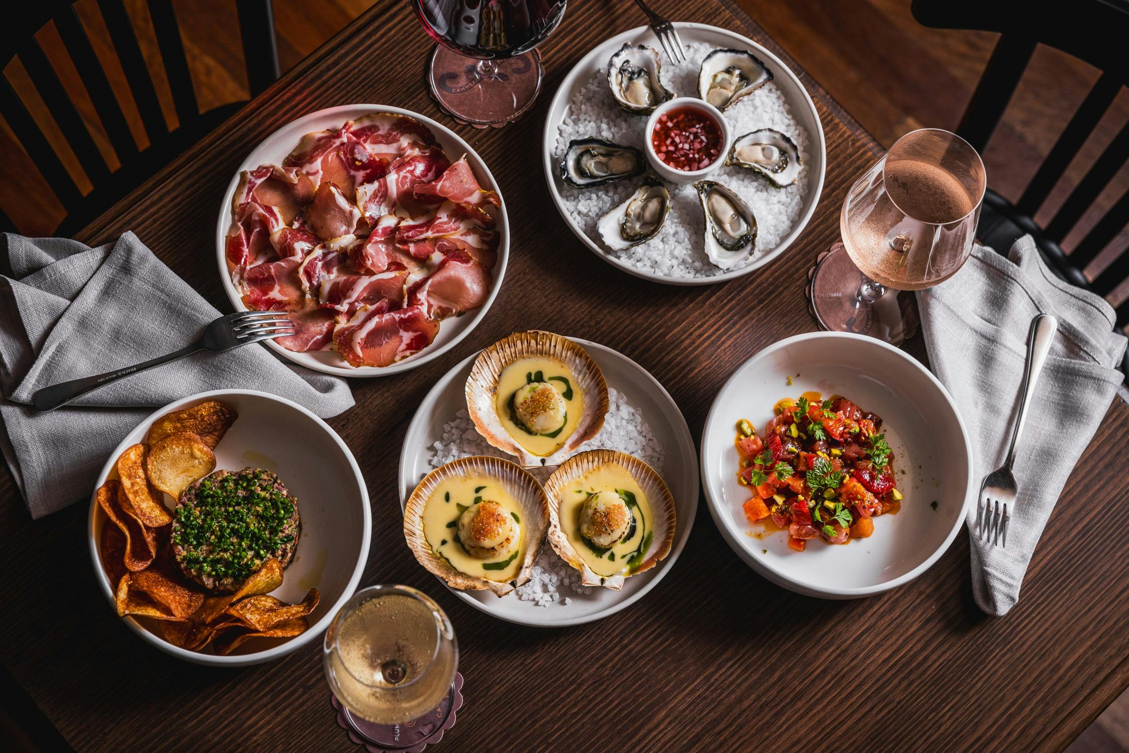 A selection of dishes including scallops, oysters