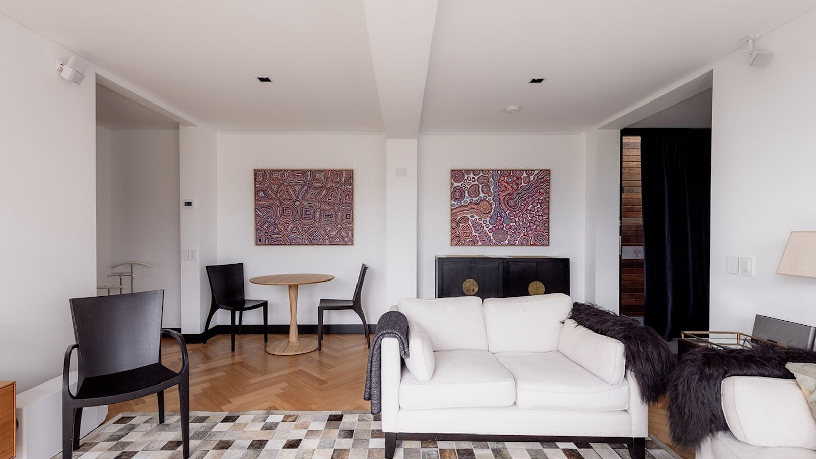 Stylish suite lounge with contemporary furnishings and natural light, ideal for social gatherings.