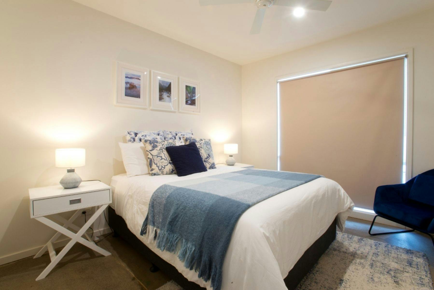 Bedroom one with a bed, blue chair and side table