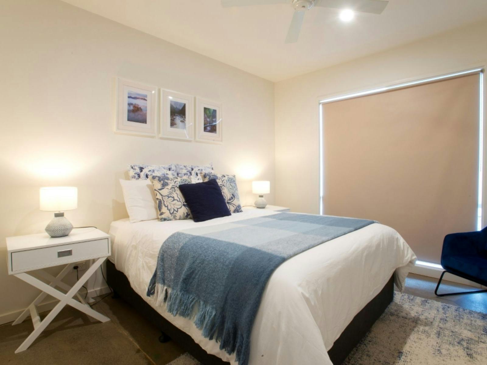 Bedroom one with a bed, blue chair and side table