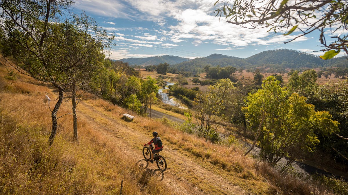 Bike rider venturing along and taken in the Brisbane Valley Rail Trail countryside
