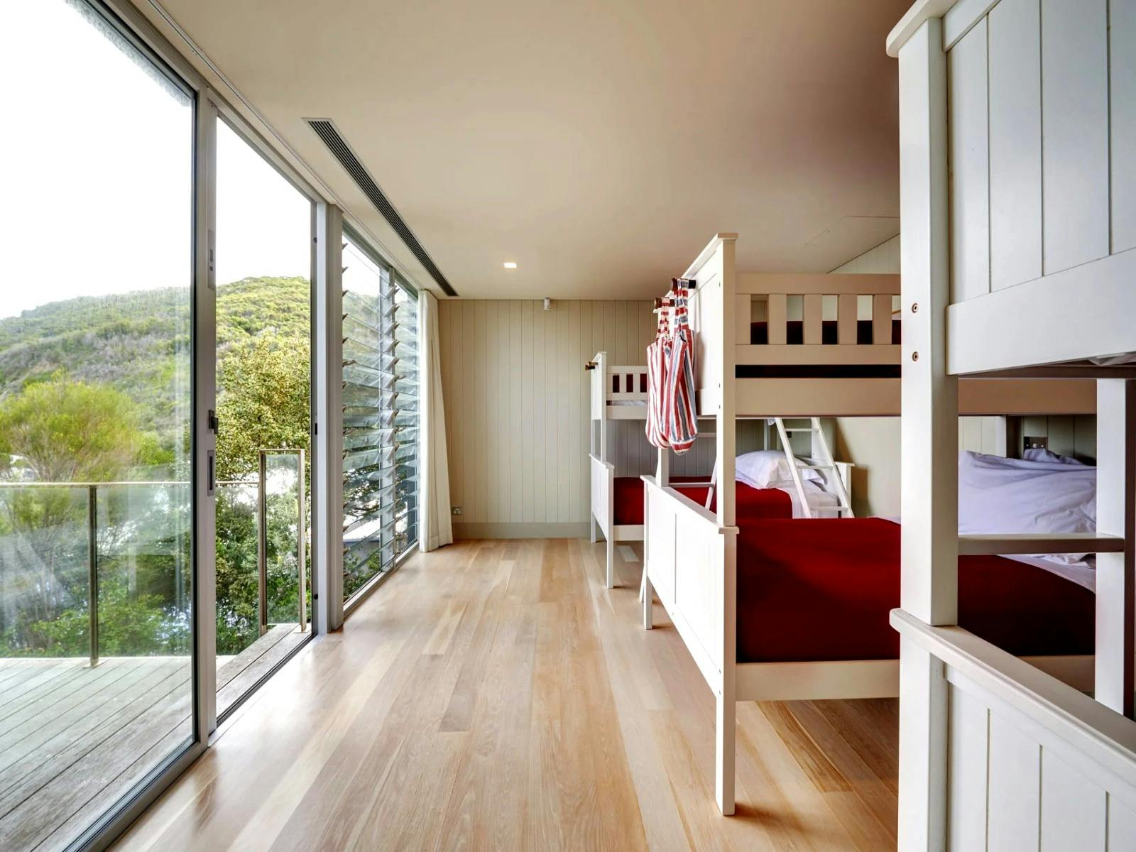 Cozy bunk bedroom with large windows offering scenic views