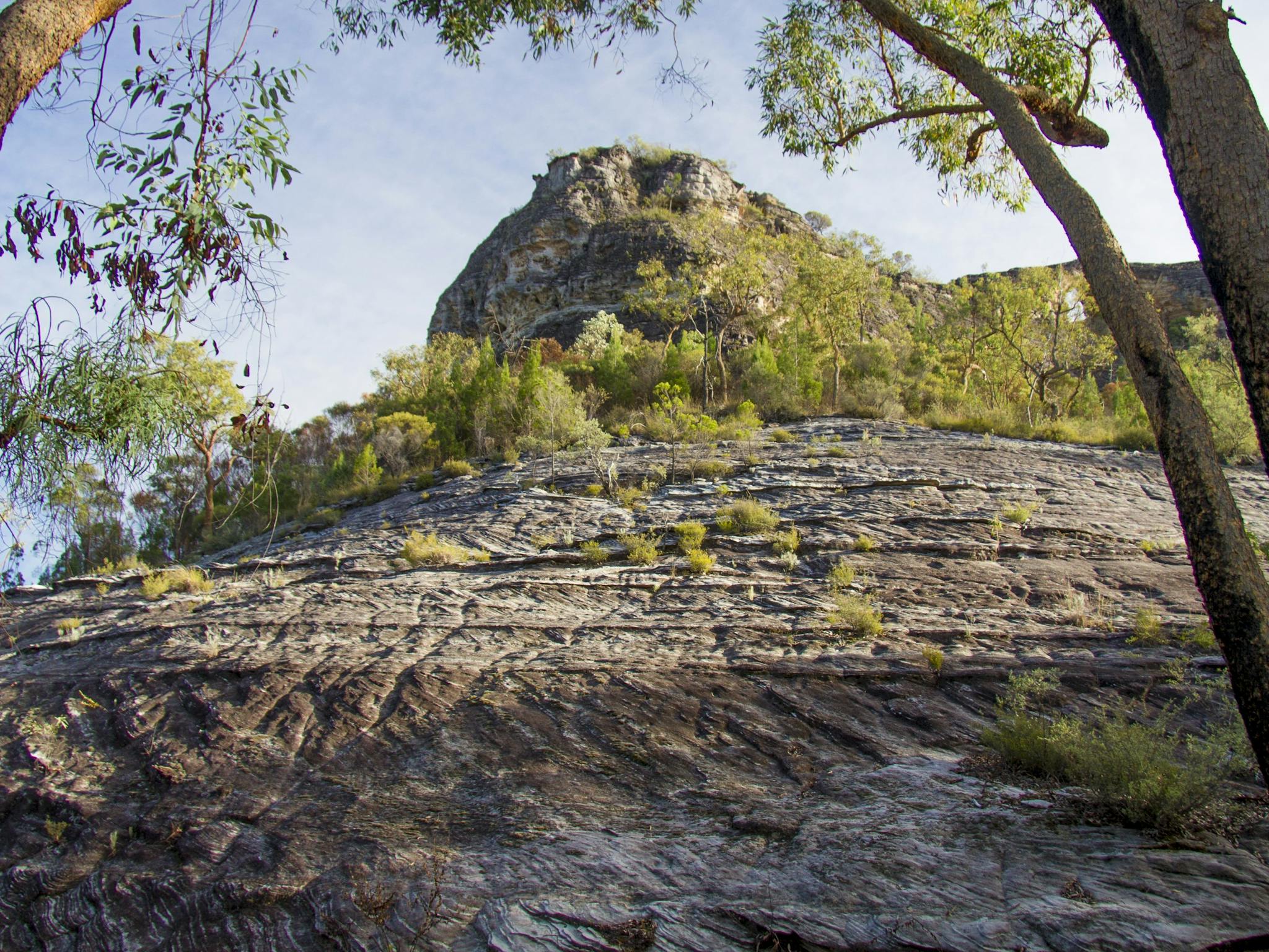 Smooth rocky outcrop rising into sky.